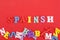 SPAIN word on red background composed from colorful abc alphabet block wooden letters, copy space for ad text. Learning