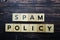 Spam Policy alphabet letter on wooden background