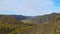 Span of the camera from left to right. Mountainous terrain. Autumn mountain river in the distance