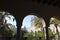 Spanish architecture. View through the arches of the palace. on palms garden in a sunny day