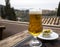 Spanish beer and glass bowl with green andalusian olives served on outdoor terrace with view on Sierra Nevada mountains in Granada