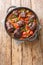 Spanish Bull Tail Stew Rabo De Toro closeup on a pot on the table. Vertical top view