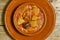 Spanish callos in an earthenware dish on a wooden table