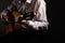 Spanish classical guitar and guitarist`s hands up close on a black background with copy space