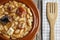 Spanish fabada in an earthenware dish and a wooden fork