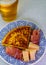 Spanish food and drink, glass of fresh beer and portion of potato omelette tortilla de patatas with onion served with cheese and