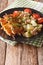 Spanish Food: kebab Pinchos Morunos and vegetables salad close-up. vertical