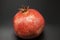 Spanish juicy ripe pomegranate closeup on a dark background