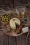 Spanish Manchego cheese with white wine, nuts and olives on wooden background