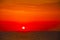 Spanish morning sun on red sky with yellow clouds by the Mediterranean sea