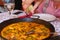 spanish paella close up photo in frying pan with shrimps, peas and lemon slice