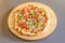 Spanish pizza with serrano ham and arugula with fine flour dough on round wooden board