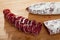 Spanish sausage fuet on a wooden table, closeup