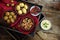 spanish tapas as party appetizers , baked olives, prawn shrimps, potatoes, tomato and garlic dip diagonal on a wooden tray with