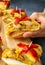 Spanish tortilla pintxos  on a wooden board. Male hand holding one pintxo.