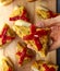 Spanish tortilla pintxos  on a wooden board. Male hand holding one pintxo.