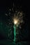 sparking sparkler in the green area. sparkler fire with blurred bokeh background. new year or St. Patrick\\\'s Day