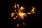 Sparkler on a black background, sparks fly in different directions,