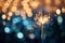 Sparkler celebration. Blurred bokeh golden and blue background with copy space