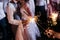 Sparkler in hands on a wedding - bride, groom and guests holding lights