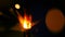 Sparkler Over Orange. Gun powder sparks shot against deep dark background. Burning fuse or bengal fire Isolated. Mojo