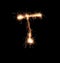 Sparklers forming letter T on dark background