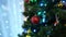 Sparkling balls and luminous garlands on the green branches of the Christmas tree