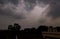 Sparkling beams of light extending from clouds during the rainy season in an Indian villgae