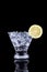 Sparkling beverage in a martini glass with lemon slice on a bl