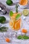 Sparkling beverage with slices of lime, kumquat and orange topped with mint