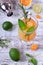 Sparkling beverage with slices of lime, kumquat and orange topped with mint