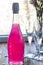 Sparkling brilliant raspberry drink. Champagne in two glasses stands on a wooden table with ice. For flowers and a garland