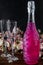 Sparkling brilliant raspberry drink. Champagne in two glasses stands on a wooden table with ice. For flowers and a garland