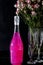 Sparkling brilliant raspberry drink. Champagne in two glasses stands on a wooden table with ice. For flowers and a garland