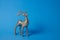 Sparkling deer decoration for Christmas. Deer figurine isolated on blue background. Christmas symbol. Decorations silver deer.