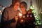 Sparkling lights and large smiles for a senior couple of grandparents celebrating the Christmas