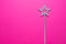 Sparkling magic wand on a pink background. Concept of celebration and magic, copy space.