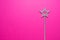 Sparkling magic wand on a pink background. Concept of celebration and magic, copy space.