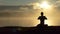 Sparkling man sits on a lake bank and practices yoga at sunset in slow motion