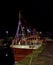 The Sparkling Rose moored in Arbroath Harbour with strings of Christmas Fairy lights between its Masts and the Wheelhouse.