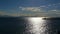Sparkling water surface , horizon, skyline, silhouettes breakwater and motor boat