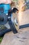 Sparks fly out from under the disc of the manual circular abrasive saw when cutting the high-pressure hose