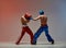 Sparring of athletic guys fighting, boxers training in red studio light, mixed fight workout