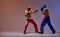 Sparring of boxers in red blue light on studio background with copy space, martial arts workout