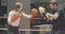 Sparring of cheerful female boxer with coach in training gloves on ring. Side view portrait of athletic strong Caucasian