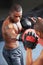 Sparring. A young focused boxer sparring with his partner in protective gloves.