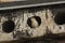 A sparrow peeks out of a hole in a concrete slab