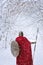 Spartan warrior walks in winter forest in traditional red cape.