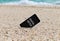 Spartphone with  text digital detox written in its screen placed in the sand of a beach