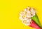 Spattered popcorn on yellow background. Two cups of popcorn on yellow background. Holiday sweets. Festive decorations.
